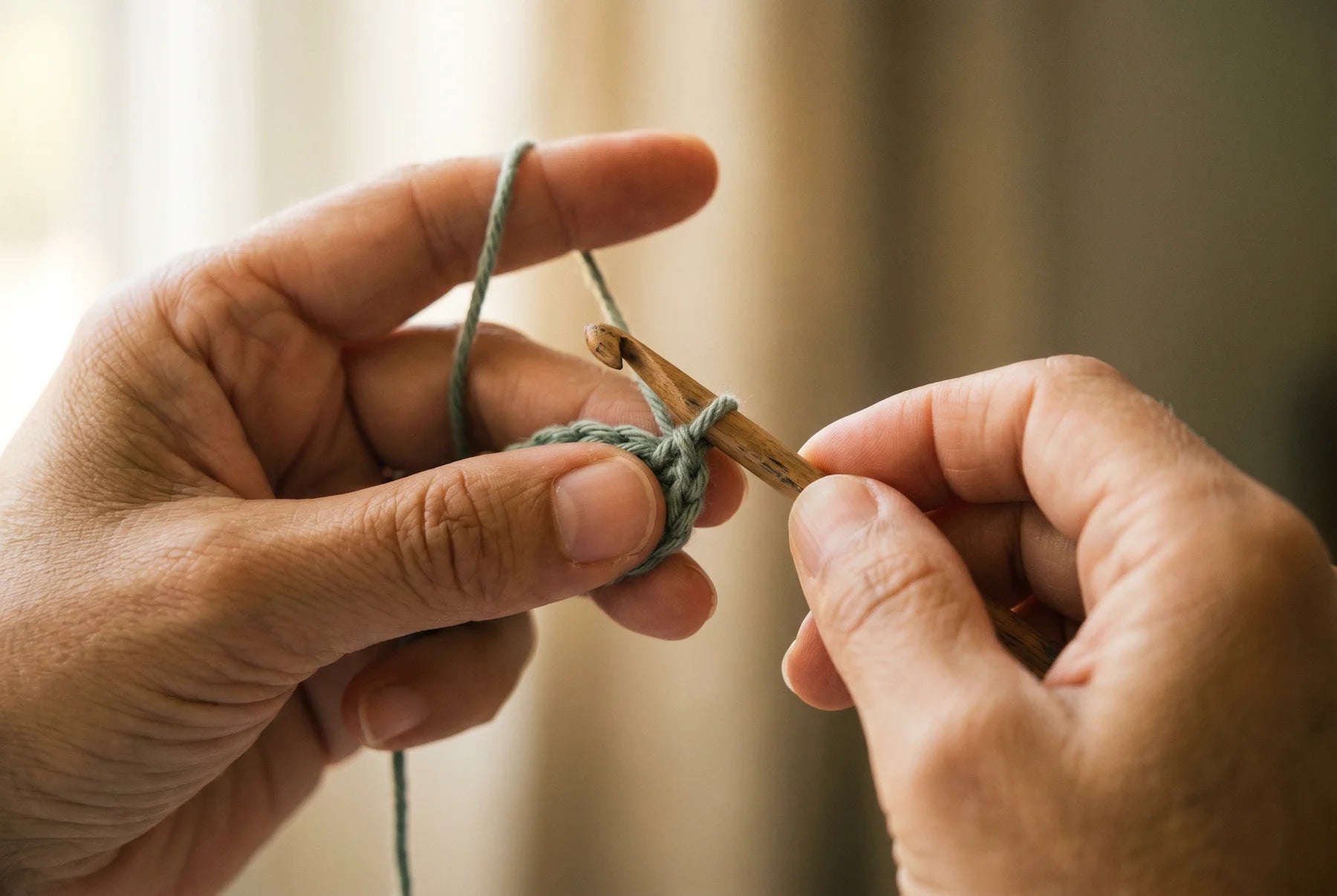 Macro de duas mãos a trabalhar crochet em coordenação